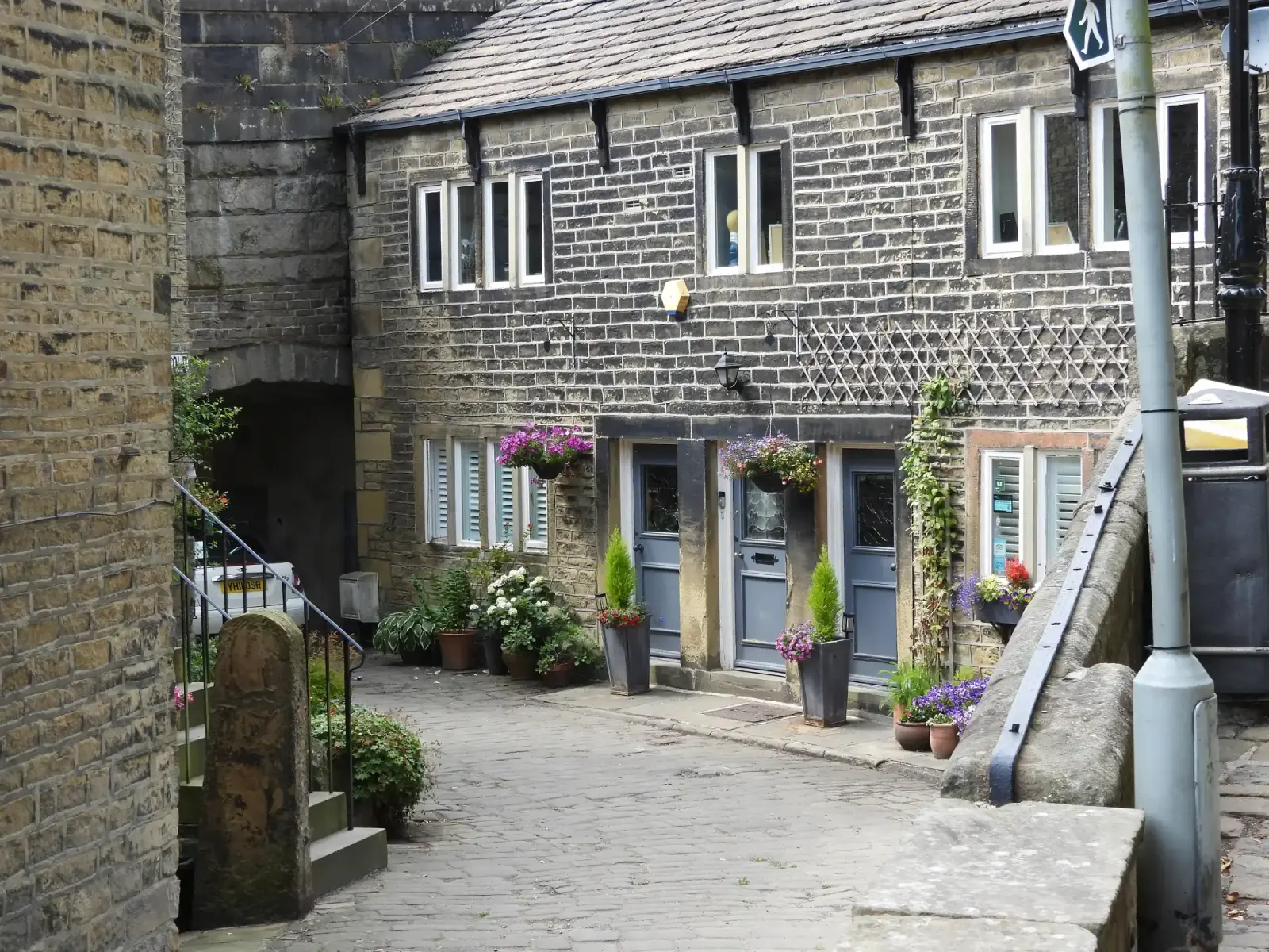 Stone buildings and flowers beside the old bridge in Ripponden