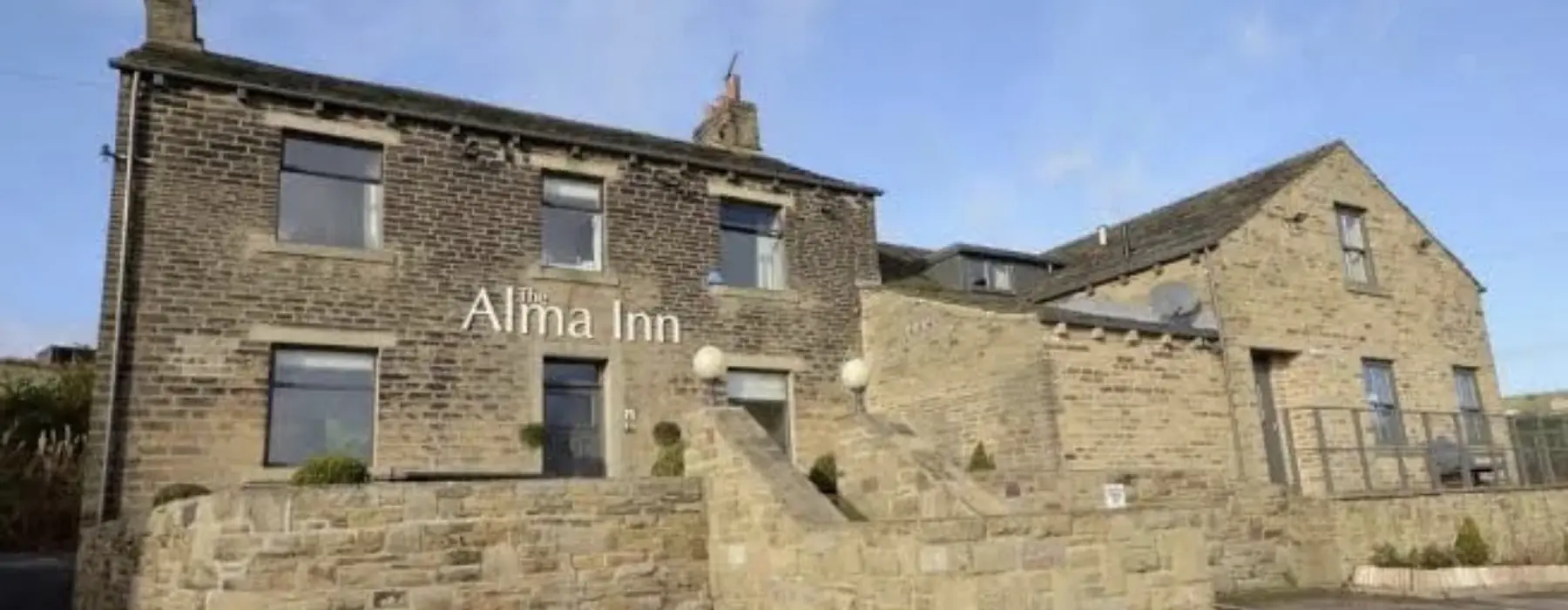 the alma inn in cottonstones in the sunshine from the front, stone brick